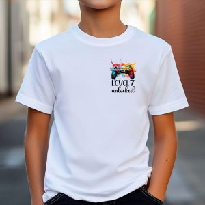 Child wearing personalised gamer birthday T-shirt with colourful Xbox or PlayStation controller graphic and 'Level 7 Unlocked' text – customisable for any age